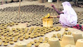 A woman potter giving shape to earthen diyas