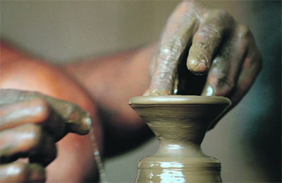 A potter makes an earthen lamp used extensively during the Festival of Lights, Diwali, at a workshop in the Dharavi area in Mumbai.