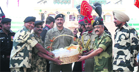 BSF officiating DIG Baby Joseph (second from left) and Pakistan Rangers Wing Commander Mohammad Asher (centre) exchange sweets on Diwali at the Wagah border checkpost near Amritsar on Sunday.