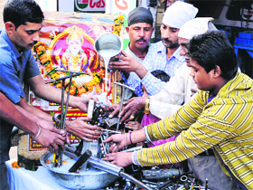 Mechanics clean their tools with milk and worship them in Amritsar on Monday.