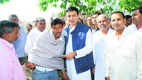 Randeep Singh Surjewala gives a cheque to an accident victim in Kaithal.