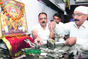 Shopkeepers wash their tools with milk while performing  Vishvakarma Day puja in Jalandhar on Monday. 