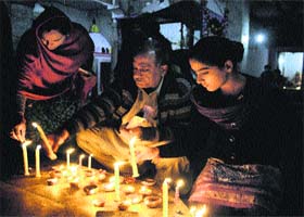 A family lights candles during Diwali at Hanuman Mandir in Srinagar on Sunday