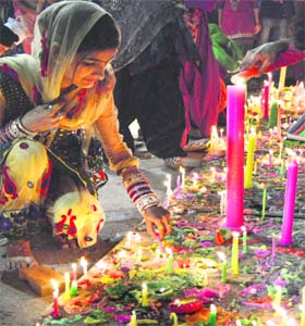 A woman lights candles in Ludhiana on Sunday