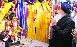 Chief Minister Parkash Singh Badal pays respects to Lord Vishwakarma at a function held by the Uttar Pradesh Kalyan Parishad in Amritsar on Monday. 