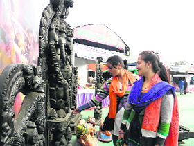 Women have a look at a wooden statue of Lord Ganesha during the Uttarakhand Saras Mela at Parade Ground in Dehradun on Tuesday.