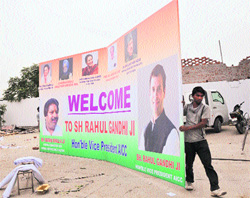 Congress workers carry a hoarding to be installed on a roadside in Jammu, where party vice-president Rahul Gandhi will address a panchayat conference on Wednesday. 