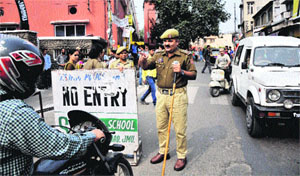 A policeman stops a motorcyclist at the Parade area of Jammu on Tuesday. 