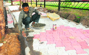 A road construction worker installs paver blocks at Sector 29 in Chandigarh on Wednesday. 