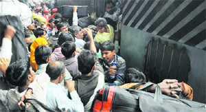 Migrants struggle to board the train at the Ludhiana railway station.  