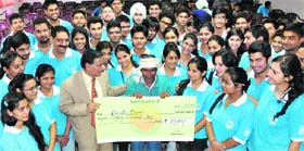 Members of Nav Sankalp donate a cheque for Rs 80,000 for the treatment of a girl to her father at DAV College, Sector 10, in Chandigarh on Thursday