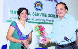 Vice-Chancellor Radhe Sham Sharma honours a teacher on the conclusion of a camp of NSS programme officers at Chaudhary Devi Lal University in Sirsa.