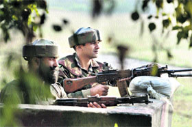 Armymen stand guard on a road in the Valley