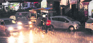 Commuters caught unawares as sudden showers lash Amritsar on Thursday. 