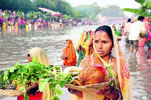 Women devotees worship the setting sun on the occasion of Chhath Puja at the Sirhind Canal in Bathinda on Friday.