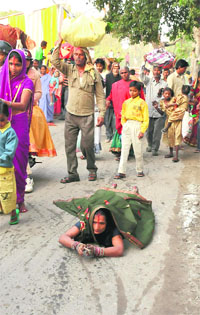 A woman prostrates during Chhath Puja near the Sirhind Canal in Bathinda on Friday.