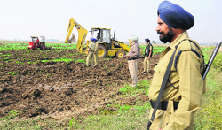 GMADA officials oversee work on the land in Mohali on Friday. Tribune photo: Vicky Gharu