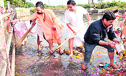 Patanjali Ayurvedic University Vice-Chancellor Acharya Balakrishna cleans the Kankhal-based Ganga ghat in Haridwar on Friday