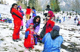 Tourists enjoy in the Solang valley, 13 km from Manali, on Friday.