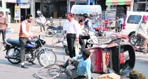 A rickshaw-puller falls down after colliding with a motorcyclist near Fauji Chowk on Saturday. The rickshaw-puller was allegedly coming from the wrong side. 