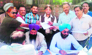 A Municipal Corporation team examines records during an awareness camp at Mayor Bakshi Ram Aroras house in Amritsar on Sunday.