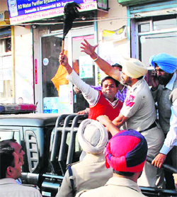 Policemen prevent a Youth Congress activist from showing a black flag to the Chief Minister during the latters visit to the city on Sunday.