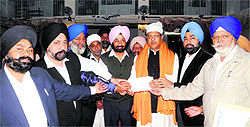 Members of the Guru Singh Sabha Gurdwara present a cheque to Suryakant Dhasmana, vice-president of the state Congress, in Dehradun on Sunday