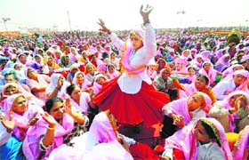 A woman dances while others sing and clap during the rally at Gohana on Sunday