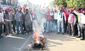 The members of PRTC Workers Union Azad burn the effigy of the PRTC general manager in Kapurthala on Monday