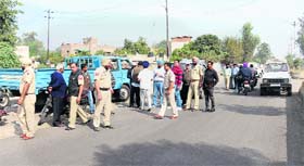 Police force deployed on the Guru Nanak Pura road to restrain vegetable vendors from setting up stalls on the road in Jalandhar on Monday
