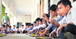 Students partake of mid-day meal at a government school. A file Photo