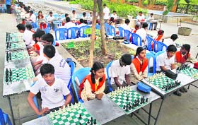 School children play chess in a public park as part of a chess promotional campaign near the venue of the World Championship in Chennai on Monday