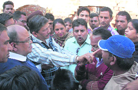 Residents of Paras Ram Nagar argue with officials of the Punjab Water Supply and Sewerage Board over the issue of stagnant sewer water and overflowing drains in Bathinda on Tuesday.