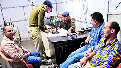 Accused Ranjit Thakur (extreme left) and MC cashier Naval Kumar (extreme right) at the Sector 17 police post on Tuesday