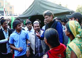 Former Indian cricketer Kapil Dev interacts with the family members of the AIIMS patients in New Delhi on Tuesday