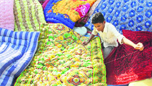 A man stitches a quilt to earn livelihood in Jalandhar on Tuesday
