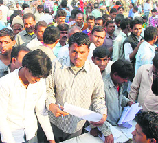 Migrants throng stalls to get ration and Aadhaar cards at a special camp held at East Mohan Nagar in Amritsar. 