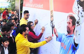Batting for God of Cricket: Actors Sharry Mann, Samiksha Singh and cricketer Manpreet Goni sign a banner to honour Sachin Tendulkar in Chandigarh on Wednesday