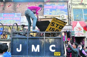 JMC employees remove encroachments at the Raghunath Bazaar in Jammu on Wednesday