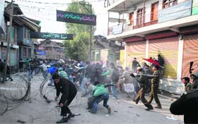 Police personnel beat mourners during a Muharram procession in Srinagar on Wednesday