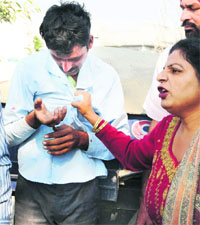 An irate woman holds the driver of the goods carrier by his collar for misbehaving with her after the accident