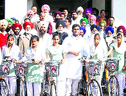 Akshit Jain (centre) gives away cycles to schoolgirls at a village in Moga on Thursday