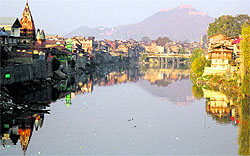The reflection of houses on the waters of the Jhelum in Srinagar make a pretty picture