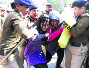 Two agitating women contractual employees of state power corporations being arrested by the police in Dehradun on Saturday