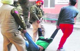 An addict undertrial, who fell unconscious outside a Kapurthala court, being carried by policemen to their vehicle on Saturday