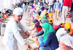 A young devotee distributes langar on the occasion of Gurpurb at a gurdwara in Mohali on Sunday. Tribune photo: Vicky Gharu
