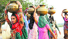 Women fetch water from a well in a village of Narnaund block in Hisar district