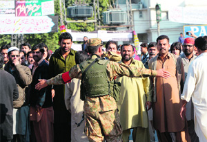 A Pakistani soldier blocks mourners at a funeral ceremony in Rawalpindi on Sunday. 
