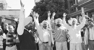 PUDA employees protest outside the PUDA office at Phase VIII in Mohali on Monday. 
