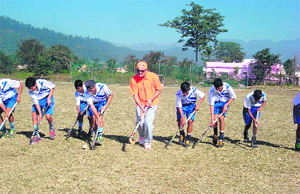 Ranjan Negi, former India hockey team goalkeeper, gives tips to players of Sports College at Raipur in Dehradun on Sunday. 